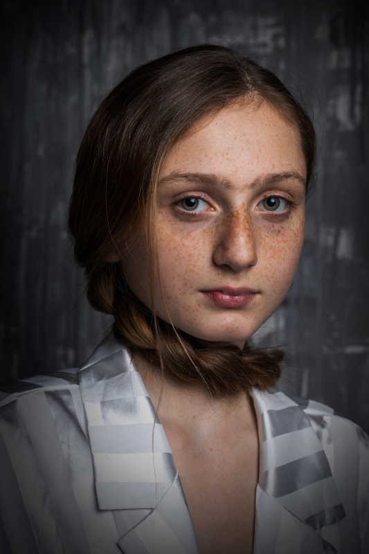 Mladá, asi dvanáctiletá dívka s dlouhými vlasy. Com je obtočený kolem krku. Velké kulaté oči, výrazné až srostlé obočí a spousta pih dávají vzhledu naprostou jedinečnost.